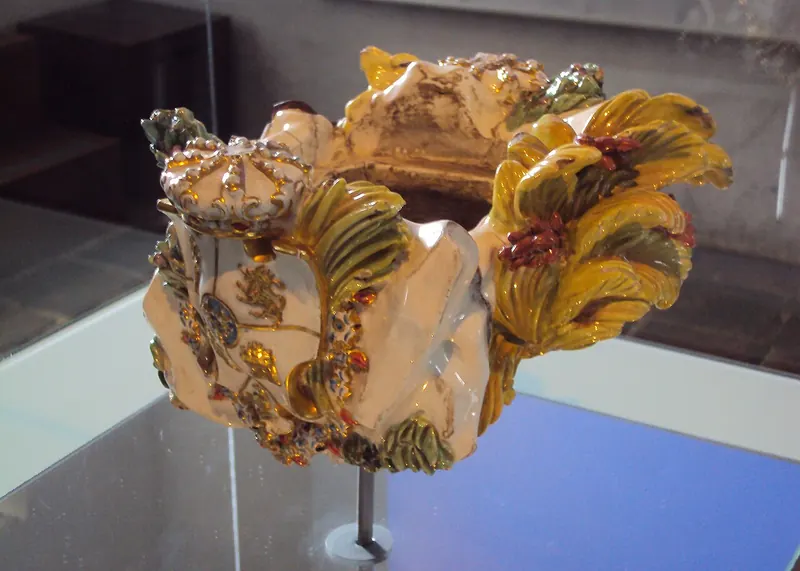 Florero de Llorente de cerámica vidriada, con escudo y hojas doradas, en una vitrina del Museo de la Independencia en Bogotá